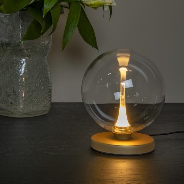 Lucide Gisela tafellamp met warm wit LED-licht in een modern interieur.